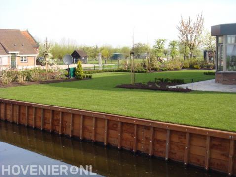 Beschoeiing bij tuin aan het water met groot gazon