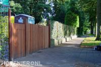 Erfafscheiding met hedera schutting en houten oprit poort