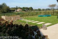 Achtertuin met terras, gazon, zithoek en gaashekwerk