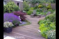 Tuin met vlonder en kleurrijke beplanting in borders 1