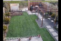 Tuin met gazon van graszoden, terras en houten pergola