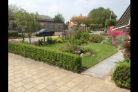 Kleine voortuin met kleurrijke beplanting en gazon