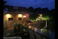 Tuinverlichting bij houten schuur met overkapping