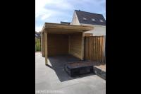 Tuinaanleg met houten overkapping, betontegels en plantenbak