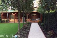 Tuin met hardhouten overkapping en kunstgras