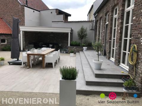 Groot modern terras van natuursteen met tuinmeubels