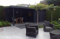 Tuinaanleg met keramische tegels en schuurtje met overkapping