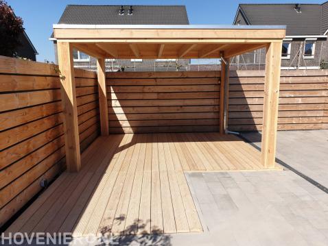 Tuin met houten schutting, overkapping en vlonder