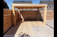Tuin met houten schutting, overkapping en vlonder