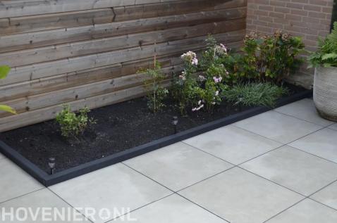 Keramische terrastegels met een border vol rozen