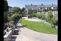 Tuinaanleg met bestrating van klinkers, gazon en verhoogde borders