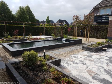 Tuinaanleg met bestrating, vijver en grote houten pergola