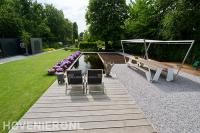 Grote achtertuin met gazon en vlonder