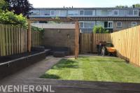Tuinaanleg met graszoden, plantenbak en houten pergola en schutting