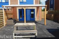 Achtertuin met overkapping en bestrating