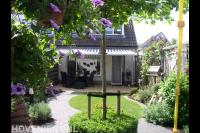 Groene achtertuin met sierbestrating en klein gazon