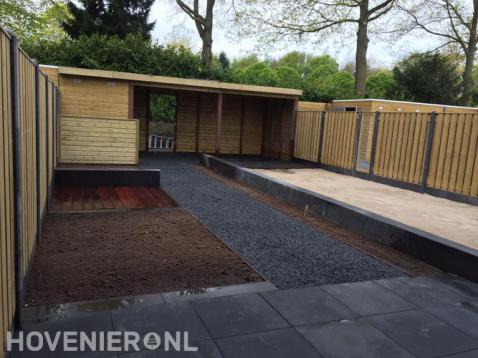 Tuinaanleg met bestrating, houten overkapping en hout beton schutting