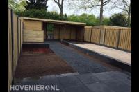 Tuinaanleg met bestrating, houten overkapping en hout beton schutting