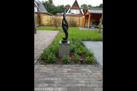 Achtertuin met sierbestrating, planten en gazon