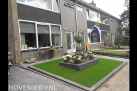 Onderhoudsvriendelijke voortuin met kunstgras en plantenbak