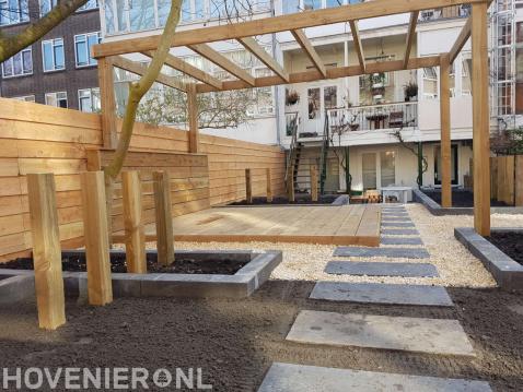 Tuin met bestrating, split en houten vlonder, pergola en schutting 2