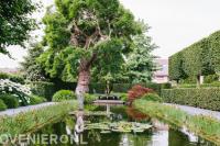 Tuin met veel groen en grote vijver