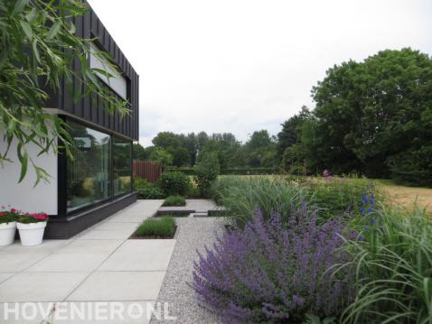 Moderne tuin met grote witte tegels, vijver en grind