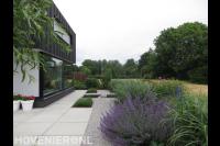 Moderne tuin met grote witte tegels, vijver en grind