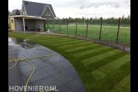 Schutting van betongaas langs nieuw gazon van graszoden