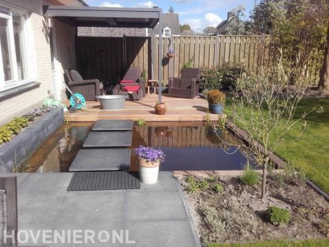 Tuin met vijver, houten vlonder en overkapping