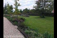 Landelijke tuin met groot gazon en kleurrijke beplanting