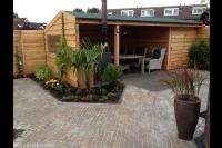 Houten schuurtje met veranda en tuinhaard