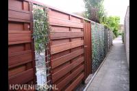 Hardhouten schutting met betongaas en poort