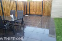 Tuinaanleg met terras, kunstgras en hout beton schutting