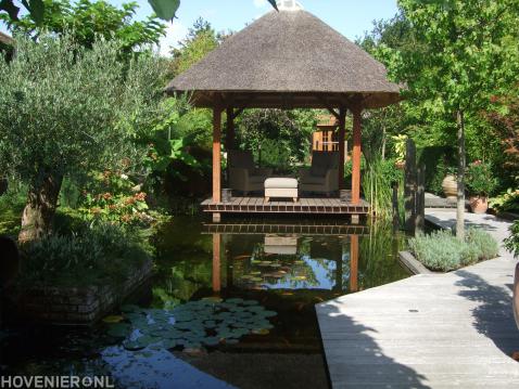 Overkapping met rieten dak op vlonder in watertuin