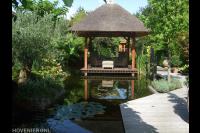 Overkapping met rieten dak op vlonder in watertuin