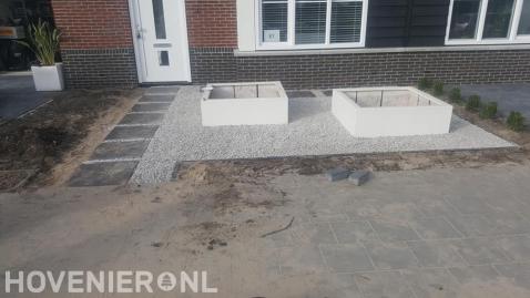 Voortuin aanleggen met grind en witte bloembakken