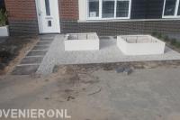 Voortuin aanleggen met grind en witte bloembakken