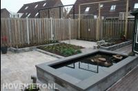 Tuinaanleg met bestrating, vijver, pergola en plantenbakken
