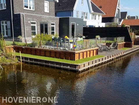 Houten beschoeiing in tuin aan het water