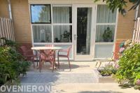 "Achtertuin met beige tegels, verhoogde borders en Geoproarte tegels"