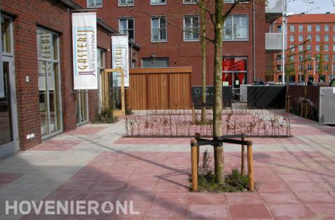 Bestrating van rode en grijze betontegels bij bedrijfspand