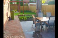 Tuinaanleg met terras, gazon en houten pergola