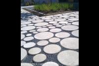 Speelse verharding met ronde betontegels en split