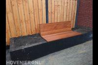 Plantenbak van stapelstenen met bankje