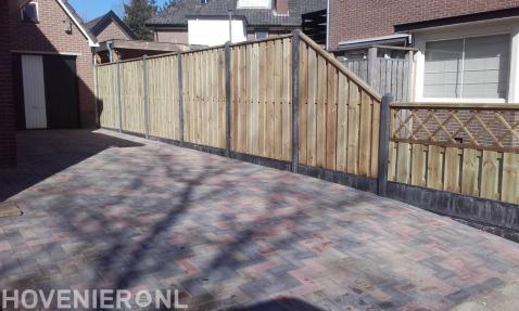 Oprit bestraten met betonklinkers en hout beton schutting plaatsen