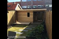 Tuinaanleg met graszoden en houten schuurtje met overkapping