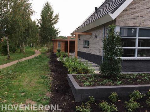 Tuinaanleg met pergola en schuurtje met overkapping