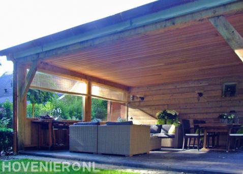Ruime houten veranda met loungeset en eethoek