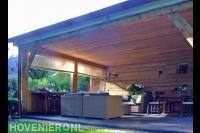 Ruime houten veranda met loungeset en eethoek